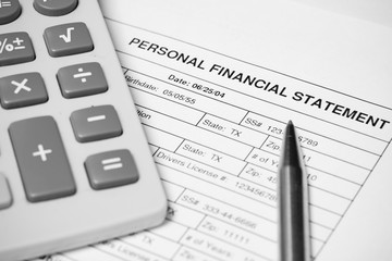 Personal financial statement document, pen and calculator
