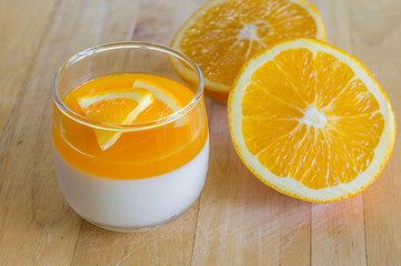 Orange Panna Cotta and Orange on Wooden background.