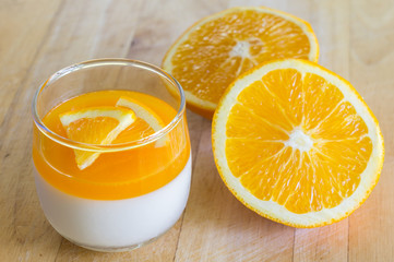 Orange Panna Cotta and Orange on Wooden background.
