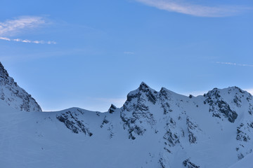 Beautiful view of mountain peak with sunset light on top against clear blue sky