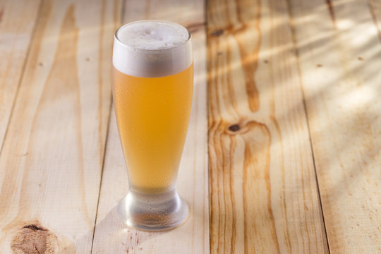 Tulipa de chopp gelado em mesa de madeira