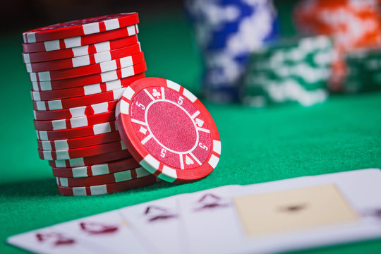 Red Poker Chips Stacked On Green Table