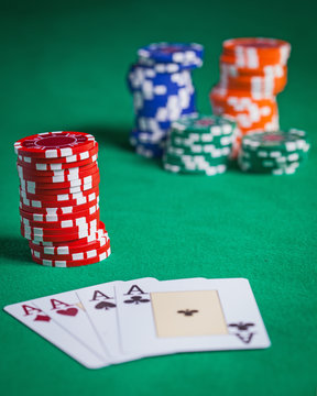 Red poker chips stacked on green table