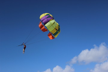 Colorful parachute flying on stormy sky.