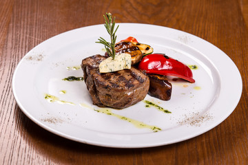 beef filet with red pepper and red wine sauce on a white plate
