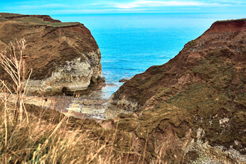 Fototapeta na wymiar A view of the beach and surrounding rock at the North Landing at Flamborough Head on the north Yorkshire coast.