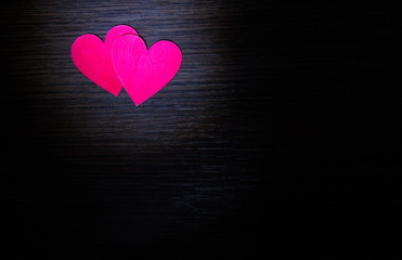 Two red hearts lie on the wooden background