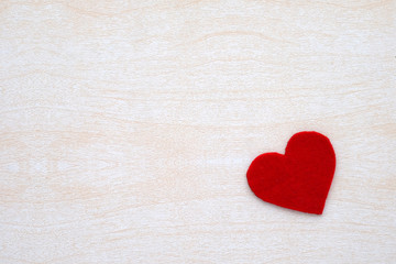 Obraz premium Red fabric heart shape on white wood background, valentine's day