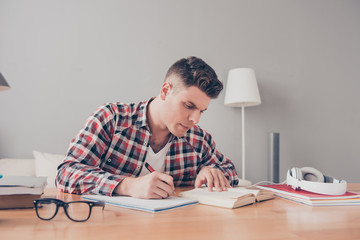 Confident smart concentrated student writing home task