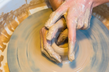 womens hands of a potter creating an earthen jar