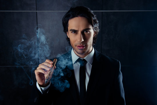 portrait of brutal handsome man  smoking a cigar