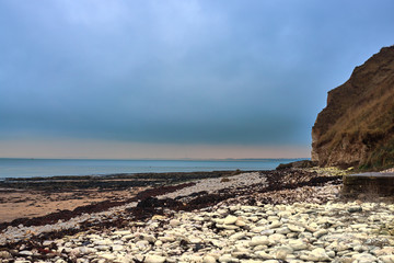 Fototapeta na wymiar A view of the beach and surrounding rock at the North Landing at Flamborough Head on the north Yorkshire coast.