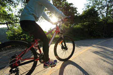 Fototapeta na wymiar young asian woman riding bike on forest trail