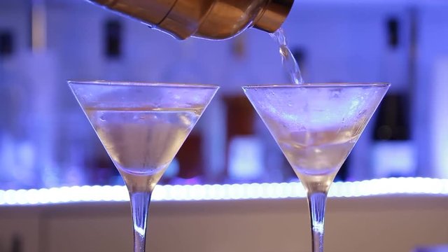 Bartender preparing gin Gibson cocktail. Woman making alcoholic cocktail with onions, close up. Handheld shot.