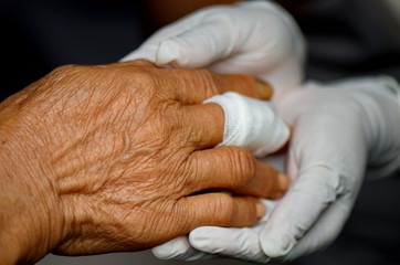Fingers wound elderly care in nurse hand.
