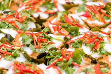 Thai steamed fish cake wrapped in banana leaf and garnished with cilantro and sliced chili
