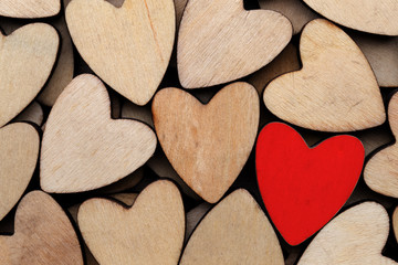 Wooden hearts, one red heart on the heart background.