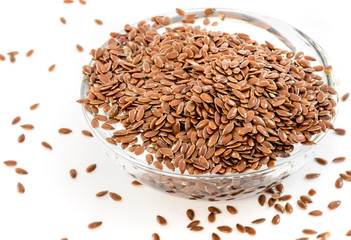 Flax seeds in transparent bowl on white background
