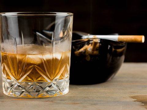 Glass of Scotch Whiskey and a Cigarette in an Ashtray