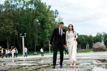 Bride and groom kissing with the fountain on the background