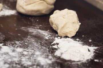 Raw dough for dumplings at wooden brown table