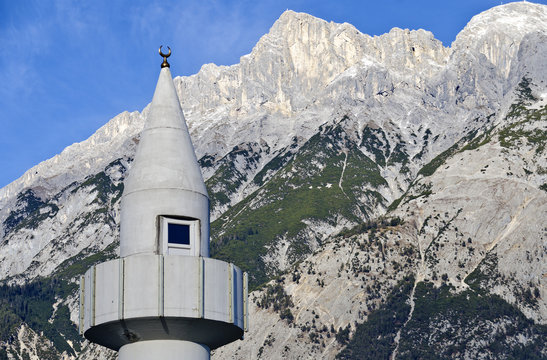 concrete minaret before mountain range