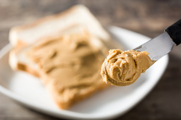 Peanut butter knife close-up with toast background