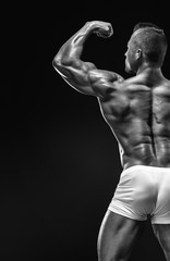 Strong Athletic Man Fitness Model posing back muscles, triceps,