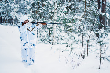 portrait of a beautiful girl in white camouflage hunter with a g