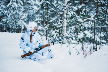 Fototapeta na wymiar portrait of a beautiful girl in white camouflage hunter with a g