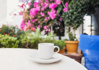 Cup of coffee in a patio with beautiful mediterranean street on the background