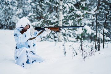 portrait of a beautiful girl in white camouflage hunter with a g