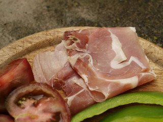 Schinken mit Tomate, Paprika auf Holzbrett