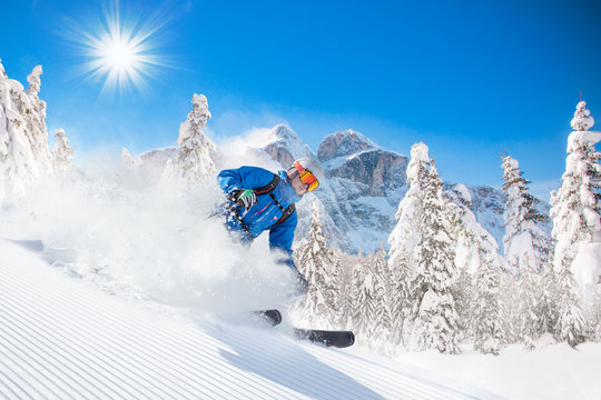 Skier skiing downhill in high mountains