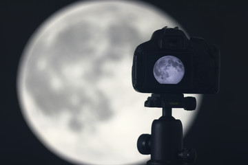 Obraz premium Moon photography. Camera with tripod capturing moon.