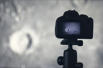 Moon photography. Camera with tripod capturing moon. Copernicus