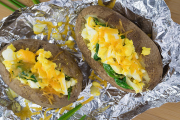 Loaded baked potatoes with eggs, spinach, cheese. © russiandoll64