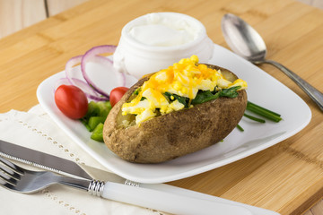 Loaded baked potato with eggs, spinach, cheese.