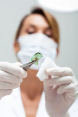médecin avec un masque chirurgical qui opère pour enlever des morceaux de verre