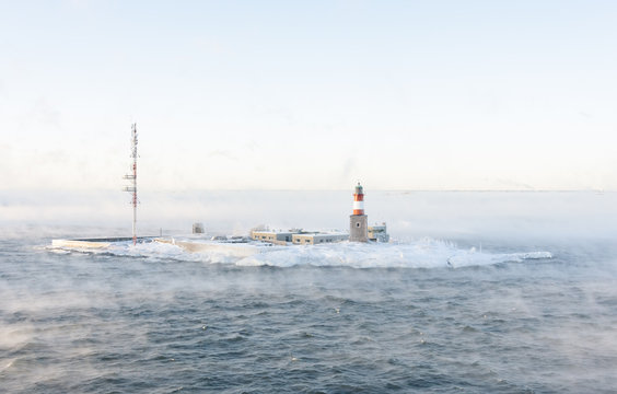 Lighthouse on an isle in misty sea
