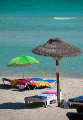 Sun loungers with parasol on the beach.