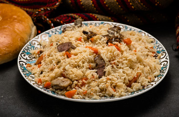 Pilaf on plate with oriental ornament and Traditional Asian breads - churek. Plov.