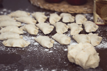 Fototapeta na wymiar Homemade Dumplings prepared on the wooden brown table by traditional way