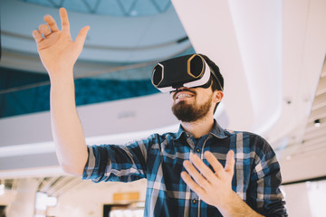Young man trying vr goggles in the shopping centre