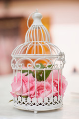 Pink flowers in beautiful vintage birdcage. Wedding decoration