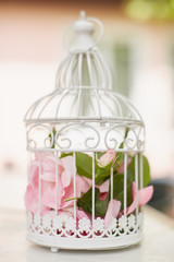 Pink flowers in beautiful vintage birdcage. Wedding decoration