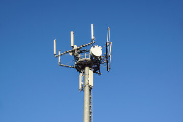 Modern Cellular Tower - Communication antenna on Blue Sky. Vertical Photography.