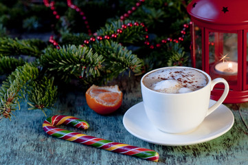 A cup of coffee on a wooden background. Coffee cappuccino with Christmas decorations and fir branches on the old wooden background. Cocoa Cappuccino Coffee Cup of coffee Wooden background