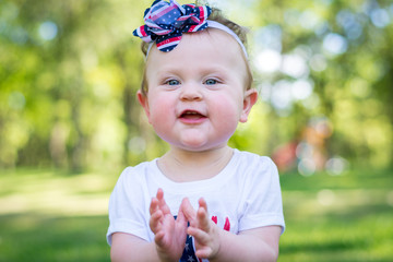Festive one year old girl in the park on the 4th of July
