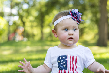 Festive one year old girl in the park on the 4th of July